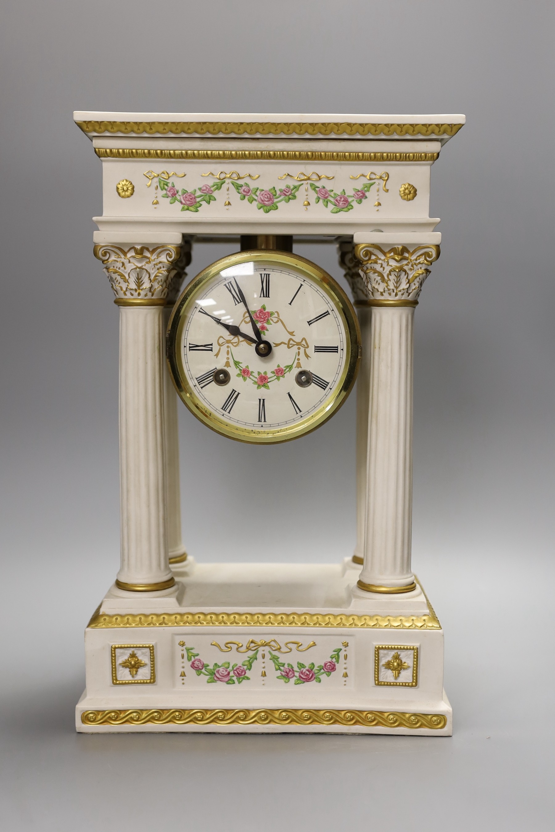 A modern ceramic portico column clock with floral and gilt decoration, with key and pendulum, 37cm tall
